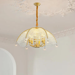 A full room shot showing a gold crystal fan-shaped chandelier as the focal point, illuminating a space with a refined atmosphere.