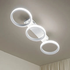 Underside view of a white LED ceiling light featuring three circular rings mounted on a rectangular base.