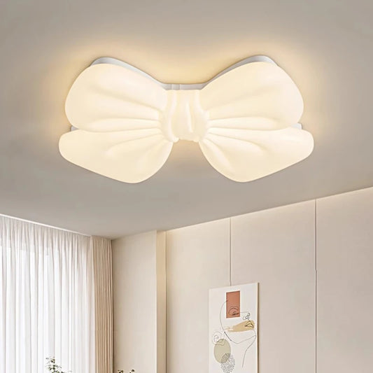 White bow-shaped LED flush mount ceiling light on a white ceiling