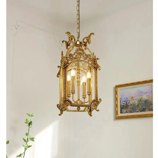 Side view of a gold candelabra cage pendant light, showing its intricate metalwork and glass panels.