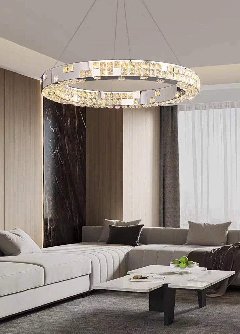 Modern living room with a chandelier, sofa, and coffee table.