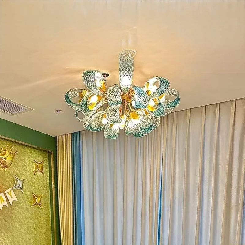 Decorative chandelier hanging in a room with curtains and a wall decoration.