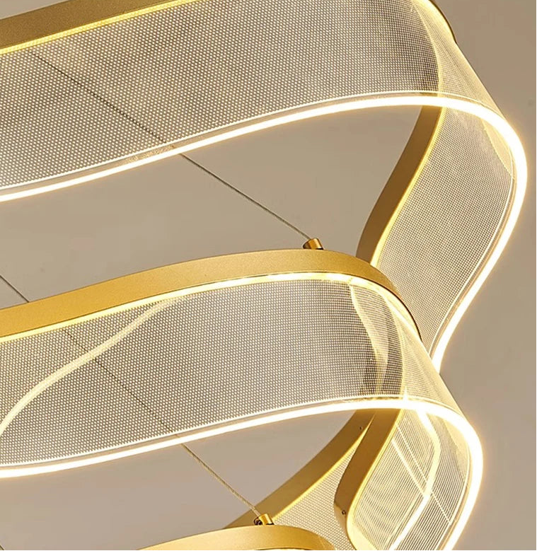 Modern gold pendant light fixture on a neutral background