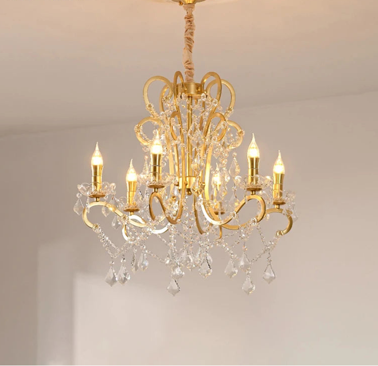 Gold chandelier with crystal accents on a neutral background