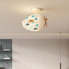 Interior view of a child's bedroom featuring an airplane ceiling light with a cloud pattern.