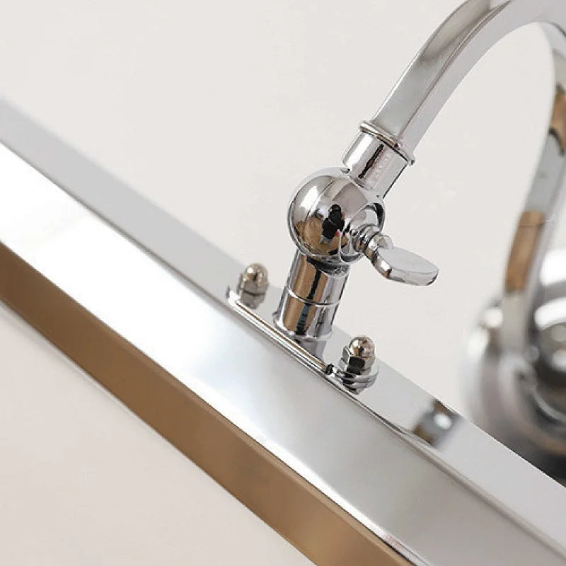 Chrome wall light on a white cabinet with a mirror reflection