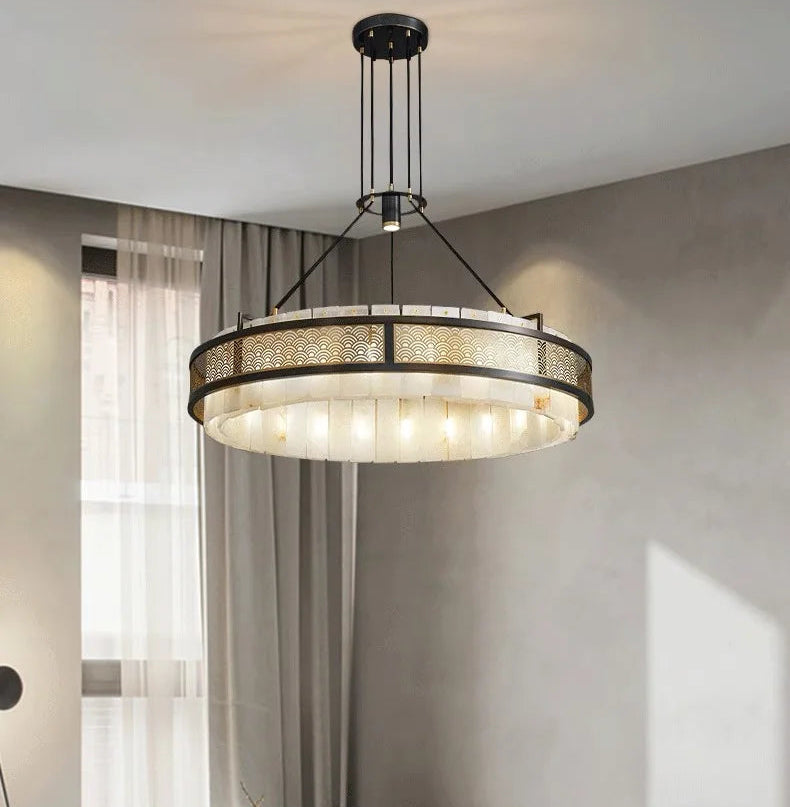 Modern chandelier hanging in a room with neutral walls and curtains.