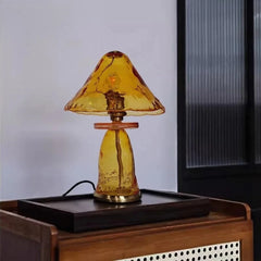 Close-up of an amber glass mushroom table lamp with a textured surface, lit from within.