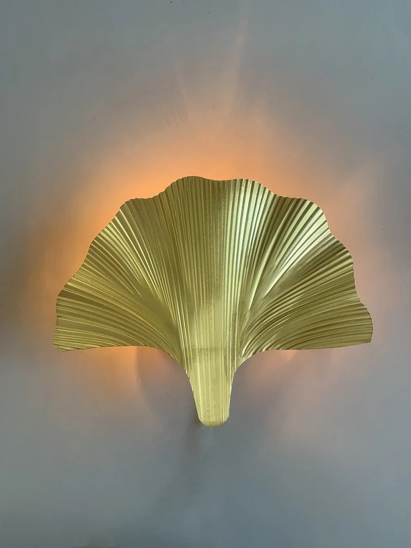 Decorative wall light shaped like a leaf on a plain background