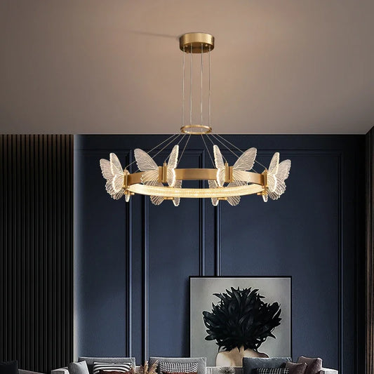 A modern gold ring chandelier with clear crystal butterfly accents hanging from a ceiling.