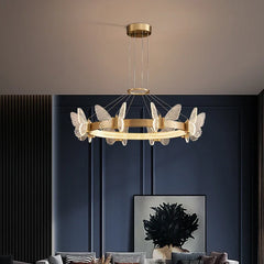 A modern gold ring chandelier with clear crystal butterfly accents hanging from a ceiling.