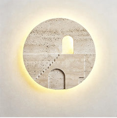 Round natural stone wall sconce with a carved staircase and archway illuminated by warm LED light from behind.