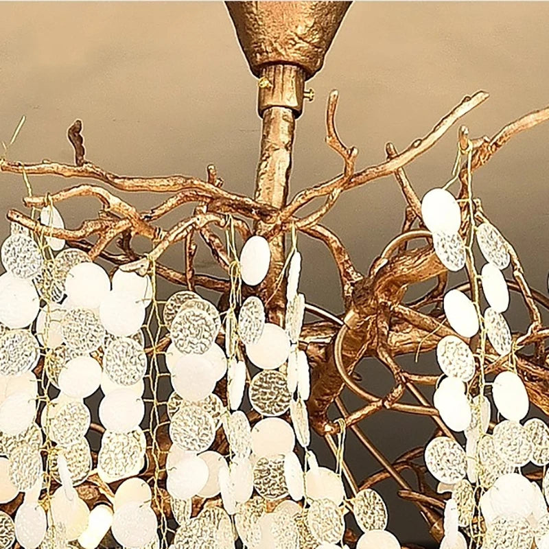 Close-up of a decorative chandelier with gold branches and white spherical lights.