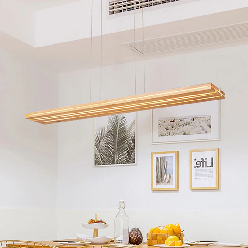 Modern pendant light fixture hanging above a dining table with decorative items.
