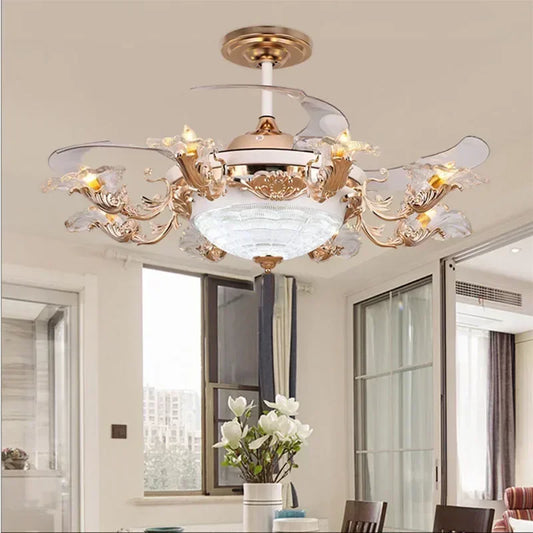 A close-up view of a gold ceiling fan light with ornate floral accents and clear crystal embellishments, set against a white ceiling.