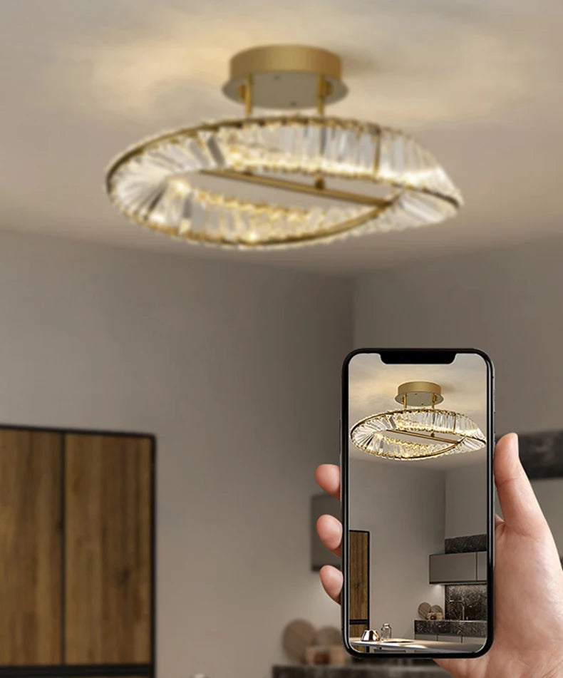 Hand holding a smartphone showing a ceiling light fixture in a room.