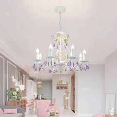 White wrought iron chandelier with floral and crystal details hanging in a living room.