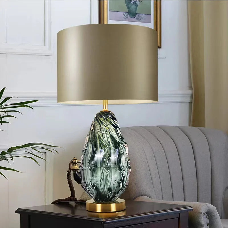 Decorative table lamp with green marbled design on a wooden side table.