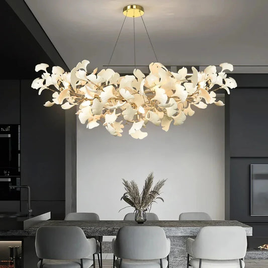 Gold ginkgo leaf cluster pendant light over a dining table