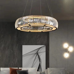 A sophisticated living room setting featuring a large, circular chrome and crystal pendant light.