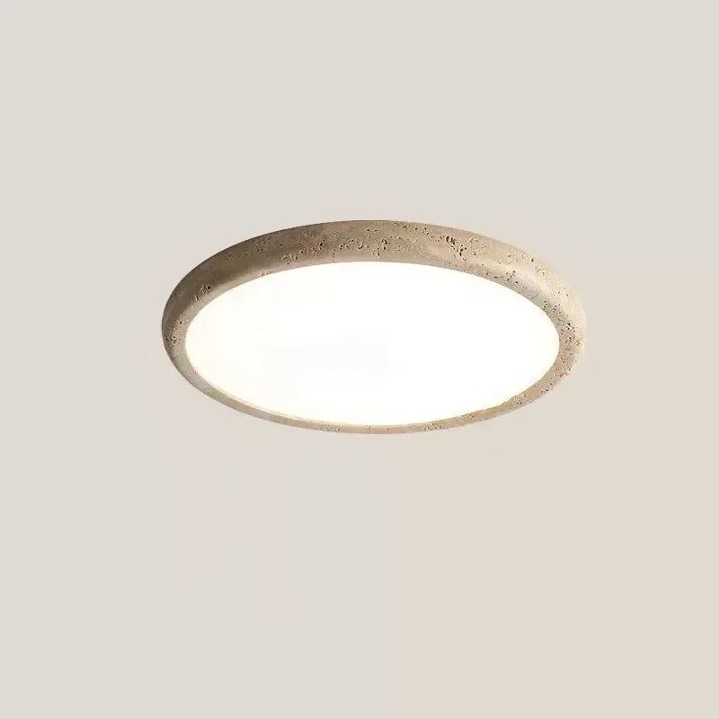 A circular flush mount ceiling light with a textured, stone-like beige frame and a smooth white diffuser.