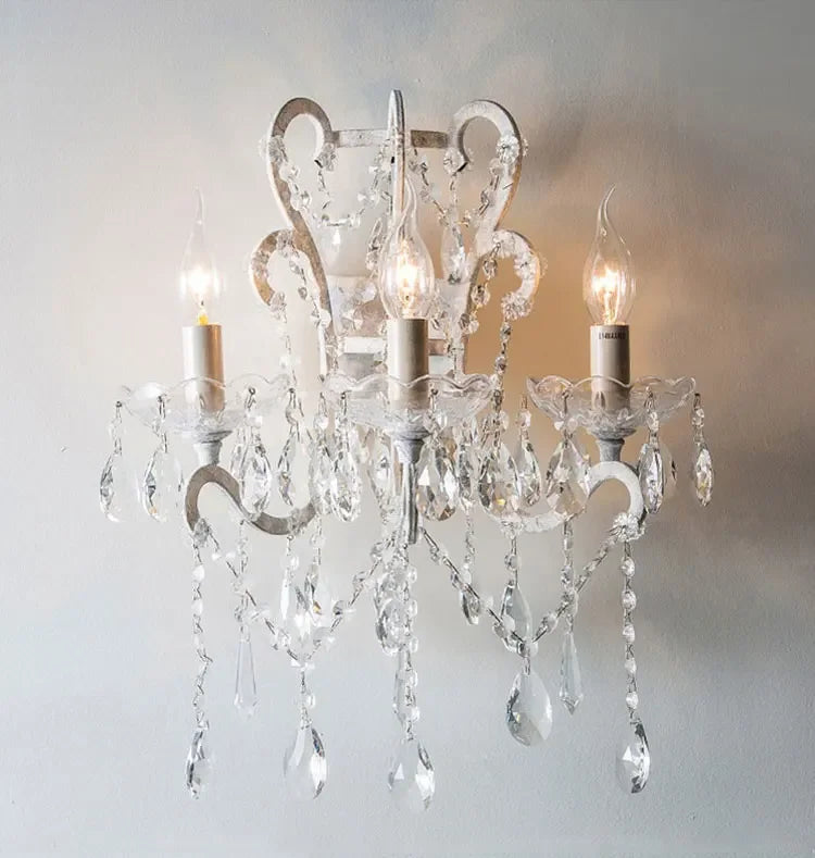 Crystal chandelier with three lights on a plain wall