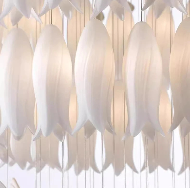 Close-up of a chandelier with white tulip-shaped lights against a light background