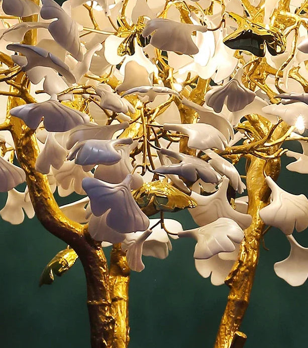 Decorative lamp with gold branches and white flowers on a dark background