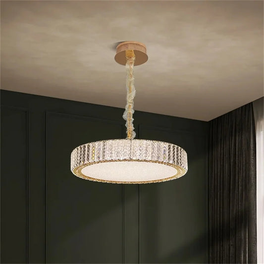Round gold chandelier with clear crystals and integrated LED lighting, mounted on a ceiling.