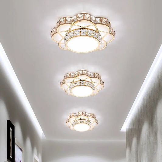 Close-up of a gold and crystal flower flush mount ceiling light with a central LED.