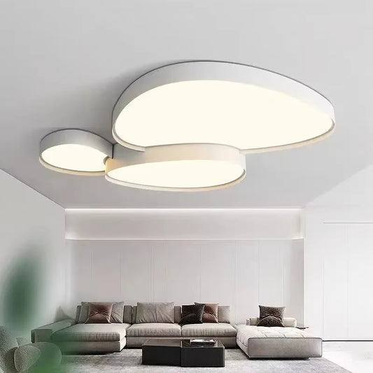 White cloud-shaped LED semi-flush mount ceiling light illuminating a modern living room with a sectional sofa.