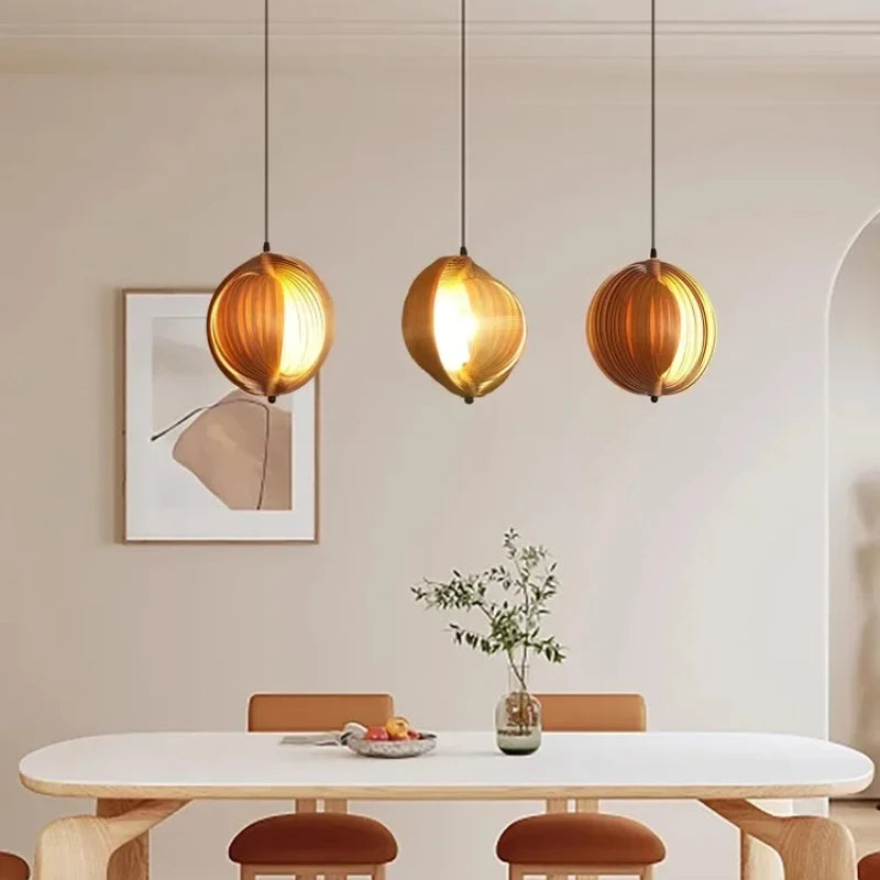 Modern dining room with pendant lights, table, and chairs.