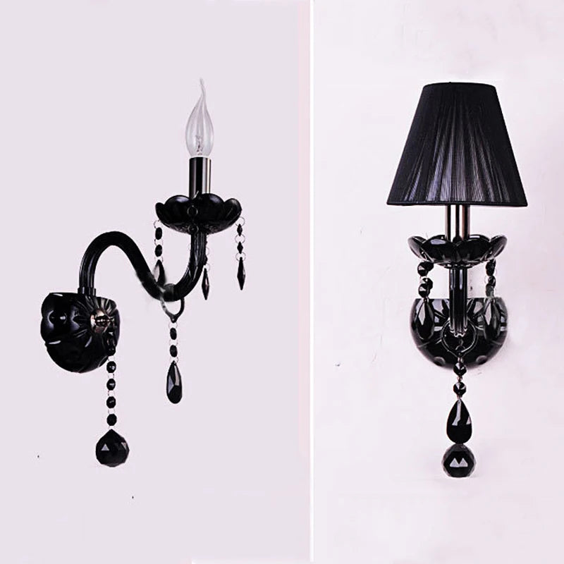 Close-up of a black wall sconce with crystal accents and a single flame-shaped LED bulb.