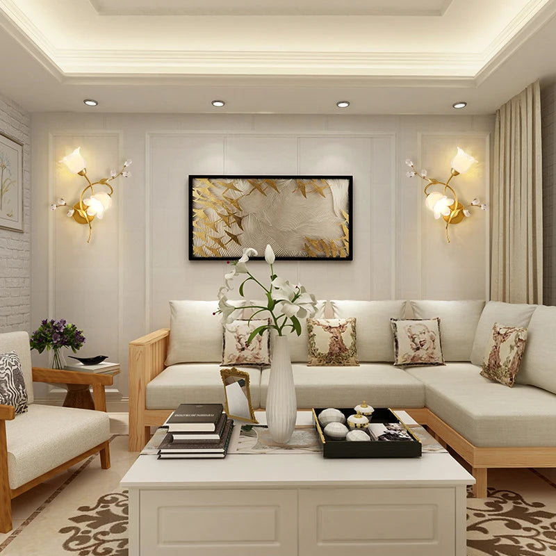 Living room featuring two gold floral leaf wall sconces flanking a piece of art above a sofa.
