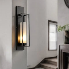 Modern wall sconce on a neutral wall with a staircase in the background