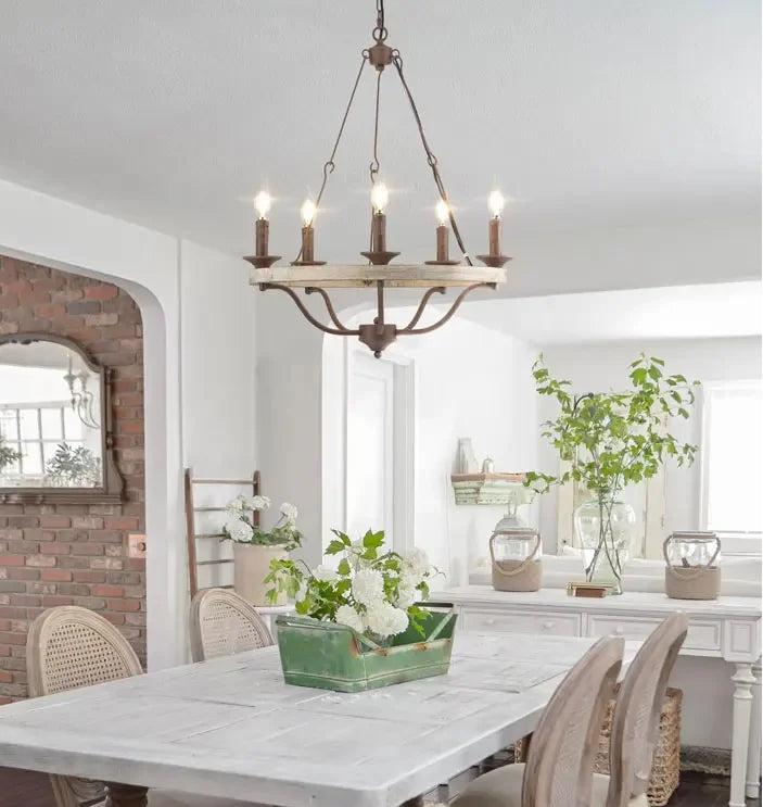 Dining room with a chandelier, table, chairs, and decorative elements.
