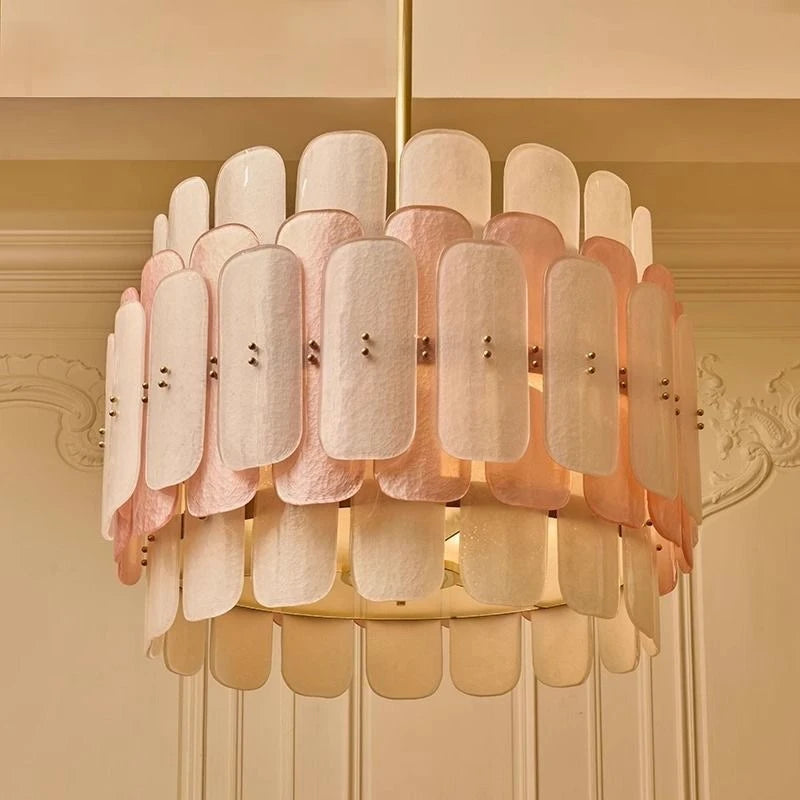 Chandelier with pink and beige lampshades on a beige wall background