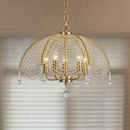 Gold metal frame chandelier draped with clear crystal beads and teardrop accents, hanging from a chain.