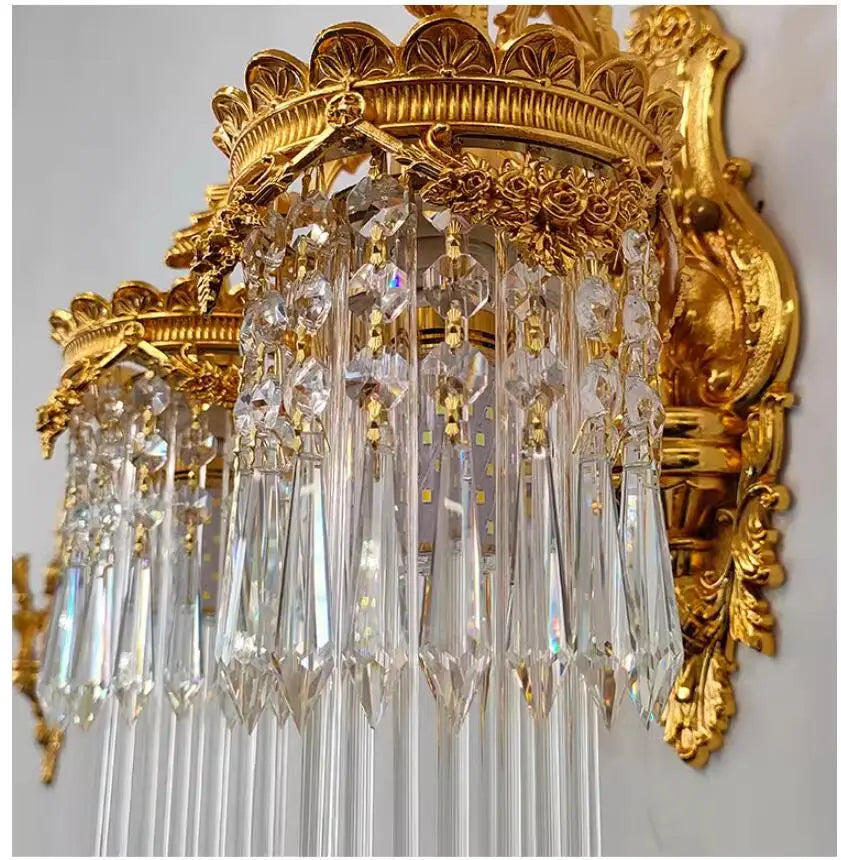 Close-up view of the crystal pendants and golden decorative elements on a wall sconce, highlighting the intricate craftsmanship.