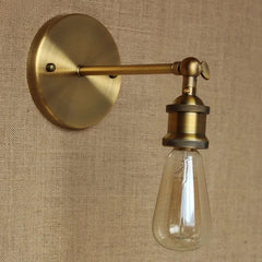 A gold cone shade wall sconce mounted on a textured wall, showcasing its industrial design.