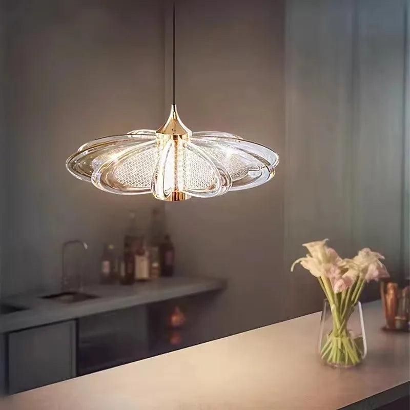 Modern pendant light fixture in a kitchen setting with a vase of flowers on the counter.