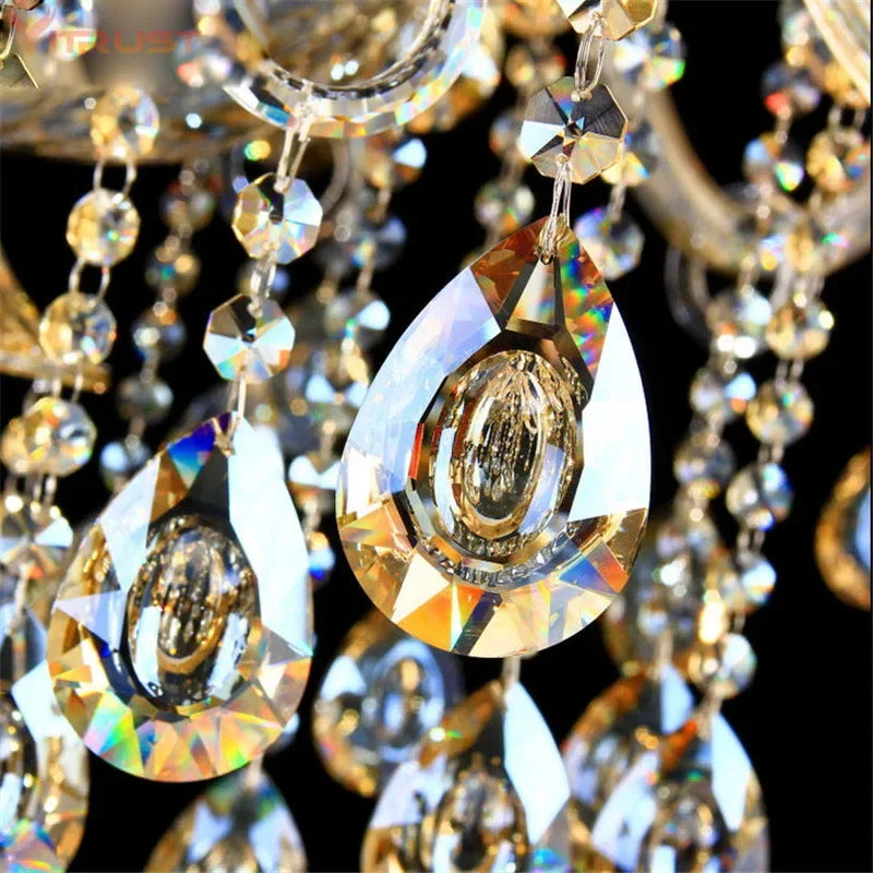 A grand 15-arm gold crystal candelabra chandelier illuminating a luxurious living room.