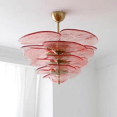 Pink glass chandelier with a layered, floral-inspired design and polished copper frame.