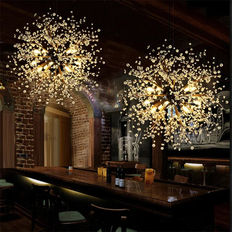 Two dandelion starburst pendant lights with warm illumination hanging over a wooden bar counter in a dimly lit room.
