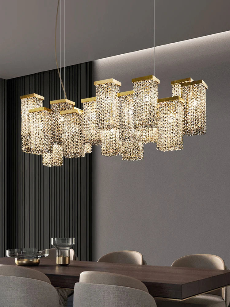 A linear arrangement of gold crystal pendant lights with cascading crystals, installed over a dark wood dining table.