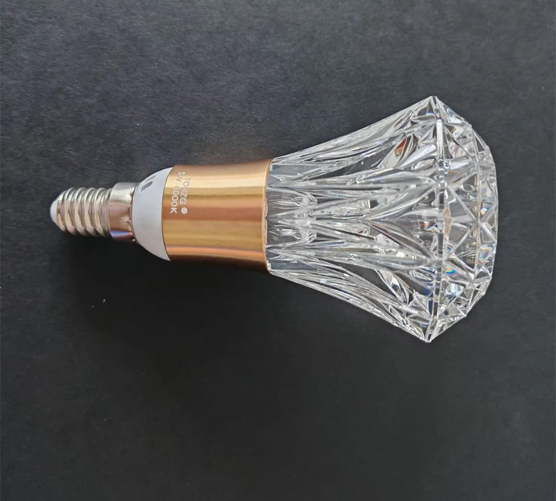 Decorative light bulb with crystal design on a dark background