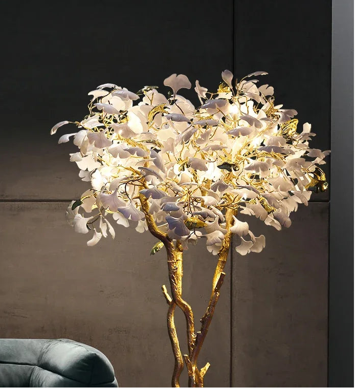 Decorative lamp with white flowers and gold branches on a dark background