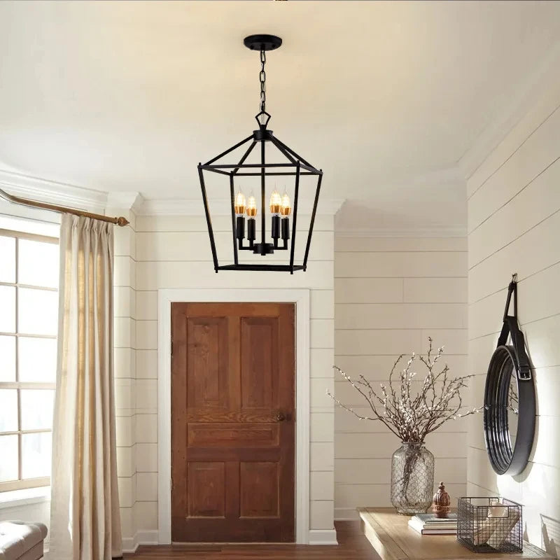 A black geometric cage pendant light hanging in a hallway with a wooden door and paneled walls.