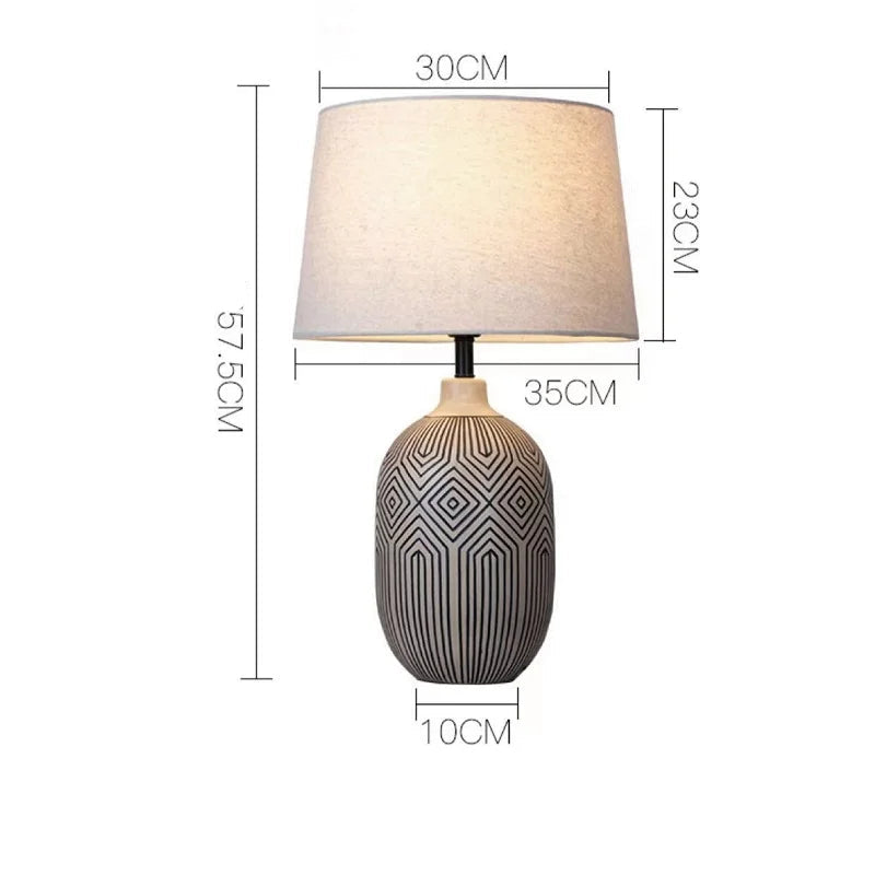 Table lamp with geometric design on base and plain lampshade, shown with dimensions.