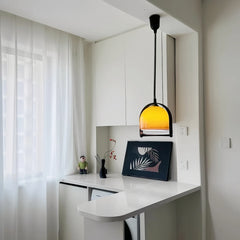 Kitchen counter area with a small amber glass dome pendant light.